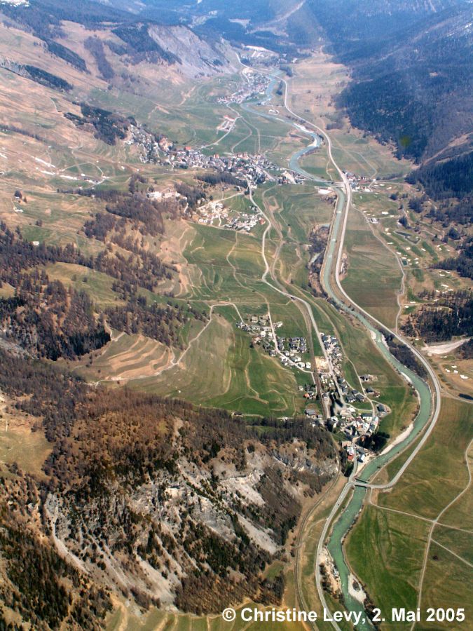 Überblick vor der Renaturierung: Ortschaft unten Madulain mit Spih. Bildmitte: gerade verlaufender Inn im Bereich der späteren Aue Batrumieu; darüber liegend: Chaut da Crusch. Grosse Ortschaft obere Bildmitte: Zuoz. Im oberen Bildrand: S-Chanf.